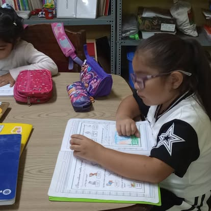 Niñas resolviendo sus cuadernos durante el refuerzo escolar en el Hogar